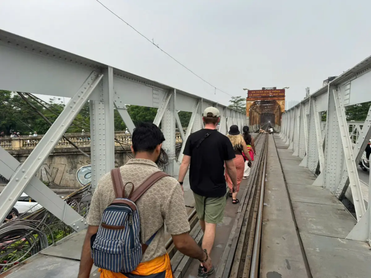 Pedestrians and travellers walking across Long Bien Bridge over the Red River in Hanoi